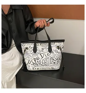 Dettaglio della borsa tote bianca alla moda con graffiti neri e stampe di gatti