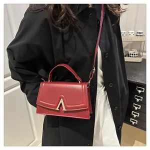 Detailansicht der roten Vintage-Handtasche mit goldenem V-Verschluss und mattem Leder-Finish