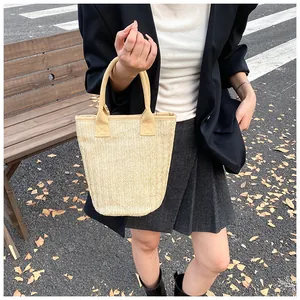 Close-up of fashionable straw tote bag showing detailed herringbone weave texture