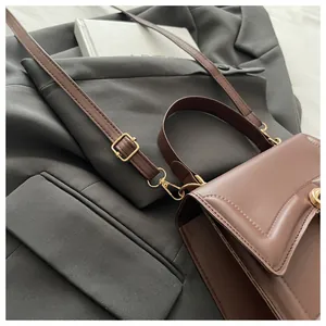 Details der dunkelbraunen Lederhandtasche mit goldenem Drehverschluss und feiner Naht