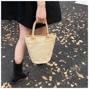 Detail of handwoven straw tote bag showing herringbone texture and zip closure