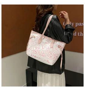 Dettaglio di una borsa tote bianca con motivi graffiti rosa e manici in pelle alla moda