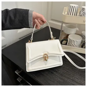 Detail der weißen Lederhandtasche mit goldener Doppelryng-Schnalle und feinen Ziernähten