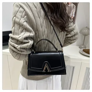 Detail der minimalistischen schwarzen matten Ledertasche mit metallischem V-förmigem Verschluss