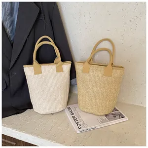Detail of large woven straw tote bags in beige and natural brown for summer style