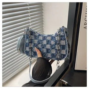 Dettaglio della borsa a mezzaluna in denim con motivo a scacchi e catena d'argento