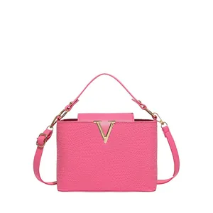 Sac à main rose vif texturé avec boucle en V dorée et bandoulière réglable