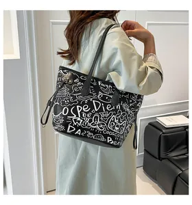 Dettaglio della borsa tote nera con stampe graffiti bianche e coulisse laterale