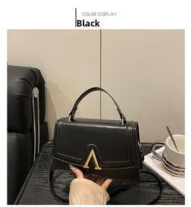 Detail der schwarzen Handtasche mit goldener V-Schnalle und stilvollem Tragegriff