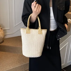 Large straw tote bag with yellow handles and woven V-pattern for summer vacation style