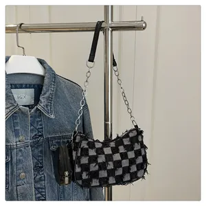 Dettaglio borsa sottobraccio in denim a scacchi con catena d'argento e mini portamonete
