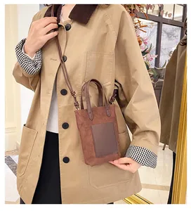Detail of a dark brown suede mini crossbody phone bag on a khaki jacket outfit