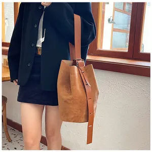 Detail of vintage matte brown bucket bag showing textured leather and shoulder strap