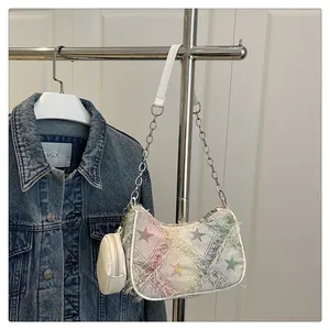 Dettaglio macro della borsa in denim a scacchi colorati con stelle e catena metallica