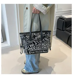 Dettaglio di una grande borsa tote nera con graffiti bianchi e stampa Faith