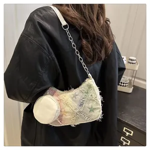 Dettaglio borsa a spalla intrecciata arcobaleno con stelle e bordi sfrangiati su modella