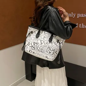 Grande borsa tote graffiti con motivi di gatti e manici neri indossata a spalla