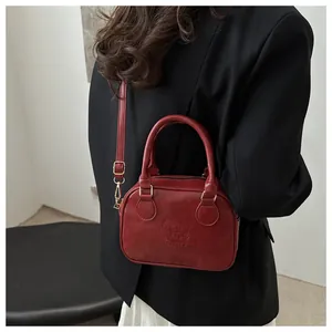 Modèle portant un sac Boston bordeaux vintage avec détails embossés lucky LHCO Smu