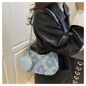 Dettaglio borsa di jeans azzurra con patchwork a stelle, frange e mini portamonete rotondo