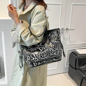 Grande borsa tote nera con motivi graffiti bianchi e sottili doppi manici da donna