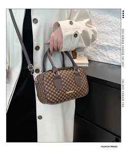 Vue détaillée du sac marron avec motif doré et bandoulière réglable amovible