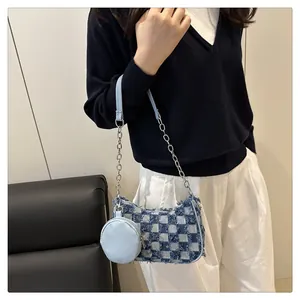 Dettaglio della borsa denim a quadretti con frange e tracolla a catena argento