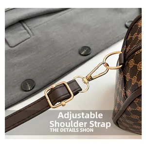 Détail macro de la bandoulière réglable avec boucles dorées sur le sac à main marron