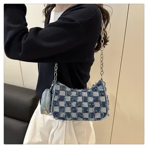 Dettaglio della borsa a spalla in denim a scacchi con catena d'argento e pochette