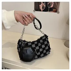 Dettaglio borsa sottobraccio in tweed a scacchi con catena d'argento e mini borsellino