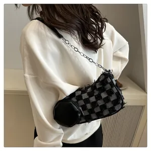 Dettaglio borsa hobo in denim a scacchi con frange e catena argentata su modella