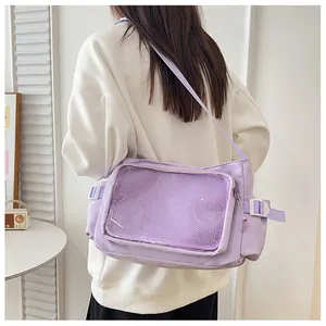 Dettaglio della borsa a tracolla in nylon viola chiaro con finestra trasparente per spille