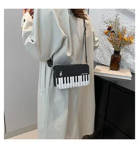 Detail of artistic piano key pattern and I LOVE MUSIC text on black and white crossbody bag