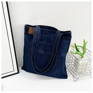 Detail showing high-density denim fabric and yellow contrast stitching on the tote bag