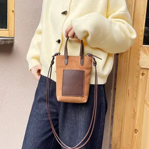 Minimalist brown suede and leather crossbody mini bag with adjustable shoulder strap