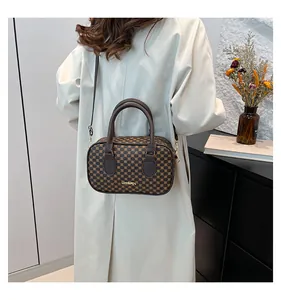 Vue détaillée du dos d'un sac polochon chic à motifs marron porté par un mannequin