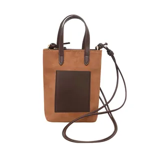 Vertical mini brown faux suede tote bag with dark brown leather pocket and crossbody strap