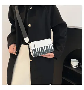 Detail view of the piano keyboard print and music theme design on a white crossbody bag