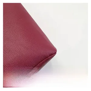 Macro shot of premium wine red litchi grain leather texture and durable stitching