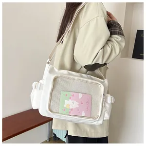 Modella indossa borsa a tracolla in nylon bianco con tasca in rete e inserto decorativo