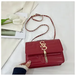 Elegant red quilted leather crossbody bag with gold tassel buckle and chain strap