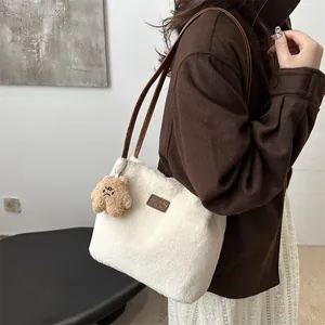Stylish white plush tote bag with brown leather straps and bear pendant shown on model