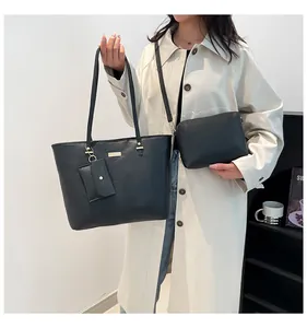 Detailed view of the 3-piece black tote bag set including a clutch and small coin purse