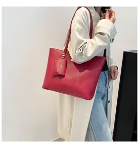 Detail of red faux leather tote bag with matching coin purse on a beige coat model