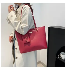 Detail of red textured tote bag with gold hardware and matching pouch accessory