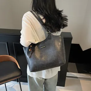 Classic black leather tote bag for women with tassel charm and large capacity for commuting
