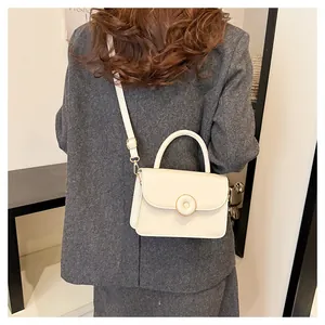 Detailed back view of a beige PU leather handbag worn over a dark grey wool suit