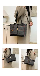 Detail of checkered tote bag with leather straps and golden clasp buckle decoration