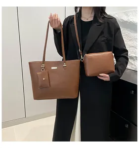 Three-piece brown leather tote bag set including crossbody and coin purse detail