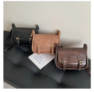 Detailed close-up of retro PU leather crossbody bags in black and brown finishes