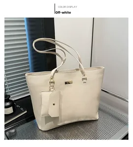 Detail of off-white tote bag set with pebble leather texture and gold hardware accents